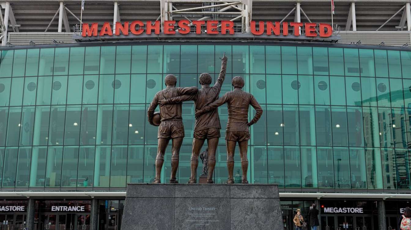 A statue of Bobby Charlton, George Best and Denis Law outside Old Trafford.